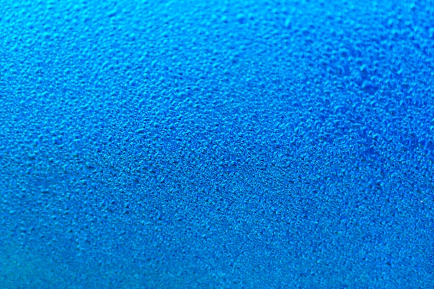 濃い青色の表面に雨滴。春の朝の気分。明るい背景や壁紙。水滴のテクスチャ。
