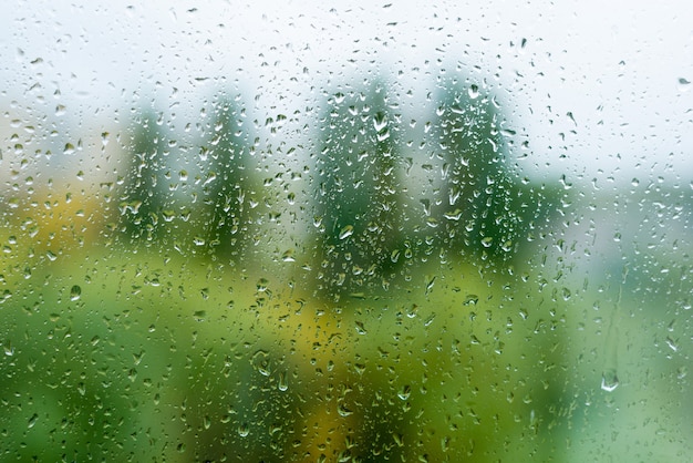 秋の窓、都市背景に雨の滴