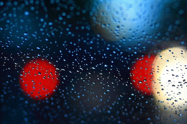 Rain drops on car glass and colorful traffic bokeh light