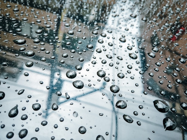 ガラスの背景に雨が降ります。