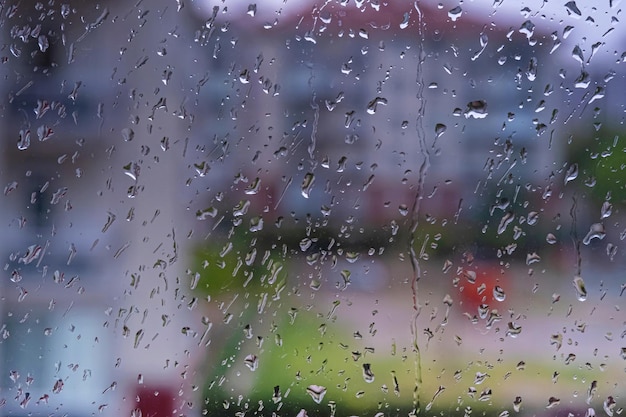 写真 窓に雨が落ちる背景をぼかした写真の窓ガラスの外で雨の日に雨が降る