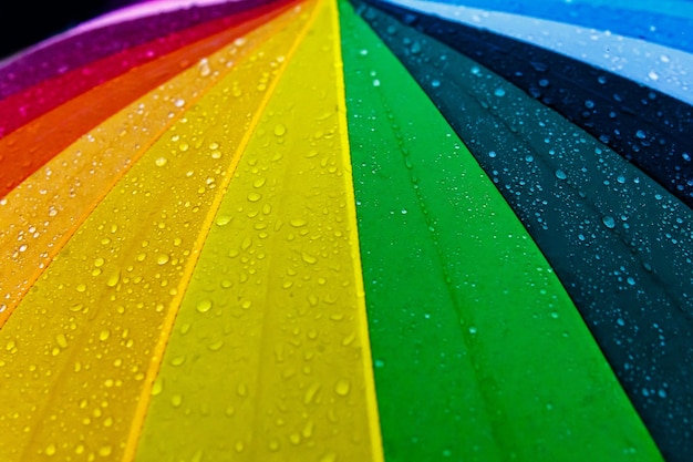 Rain drops on rainbow multicolor umbrella