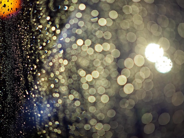 Rain drops texture on car window with colorful bokeh abstract background