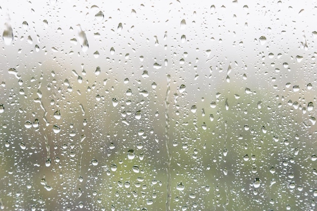 Rain drops and trickles of rain on window glass