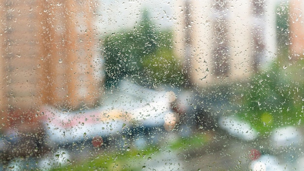 窓ガラスとぼやけた通りに雨が降る