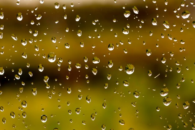 Rain drops on window glasses surface with cloudy background . Natural Pattern of raindrops isolated on cloudy background.