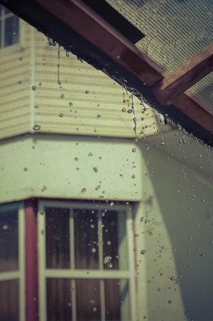 Foto la pioggia scorre giù da un tetto in giù