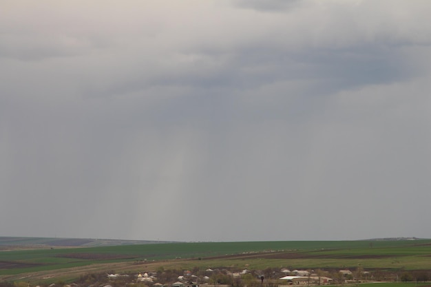 a rain storm is coming in over a field