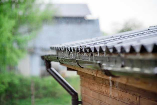 Rain water falling down from house roof in rainy season