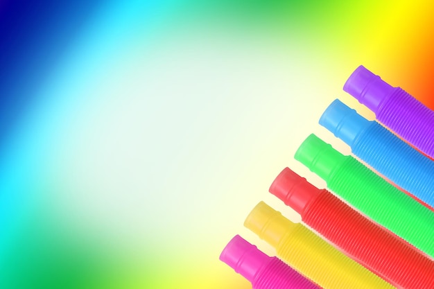 Rainbow Background with trendy colored toys pop tubes.