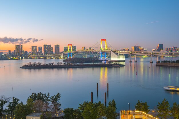 Foto rainbow bridge con vista sulla baia di tokyo e sullo skyline della città nella città di tokyo, giappone.