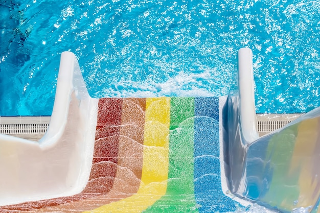 Rainbow colored aquapark slide near pool top vi