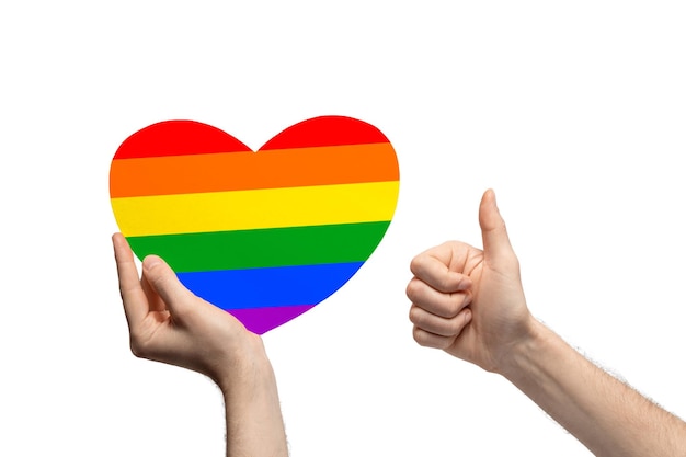 Rainbow colored cardboard heart in man's hand showing like thumb up