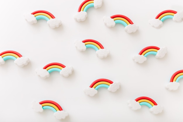 Photo rainbow erasers with smiling clouds on white background top view