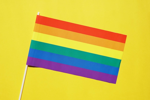 Rainbow flag gay or lgbt pride symbol on yellow background