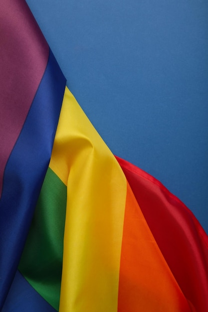 The rainbow flag LGBT on blue background Vertical photo