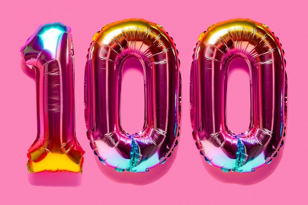 Rainbow foil balloon number digit hundred Top view Colored numeral on pink background