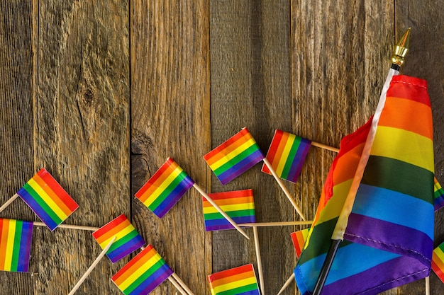 Rainbow Gay Pride small flags on wood background.