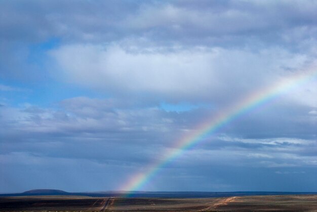 Rainbow over landscape against sky