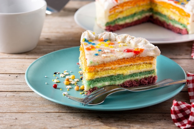 Rainbow layer cake on wooden table