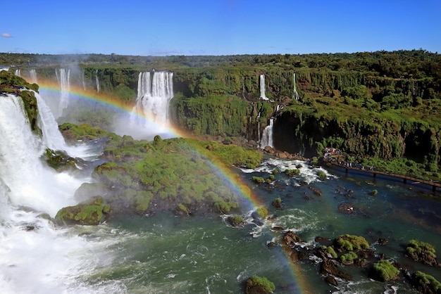 Rainbow over krachtige Iguazu Falls aan de Braziliaanse kant met veel bezoekers aan Boardwalk, Foz do Iguacu, Brazilië
