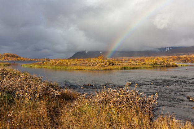 Rainbow over river in the arctic mountains of a sarek national park