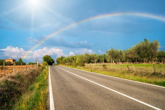 The rainbow over road and agriculture landscape.