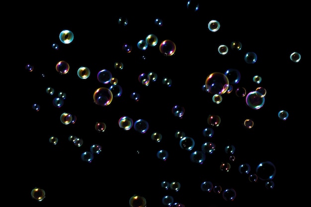 Rainbow soap bubbles on a dark background.