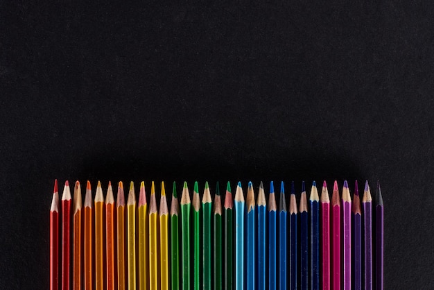 照片彩虹光谱由直排颜色铅笔孤立在黑色