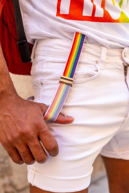 Rainbow suspenders with the hand of a gay black ethnicity man at the pride party LGBT flag