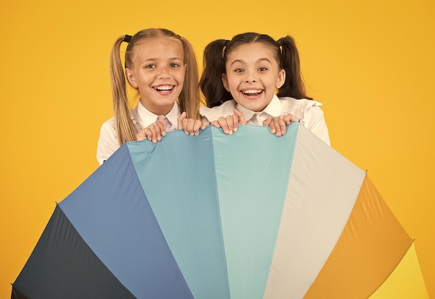 Photo rainbow umbrella colorful life schoolgirls happy big umbrella fall weather forecast place for both of us fashion accessory girls friends with umbrella rainy day happy childhood school time