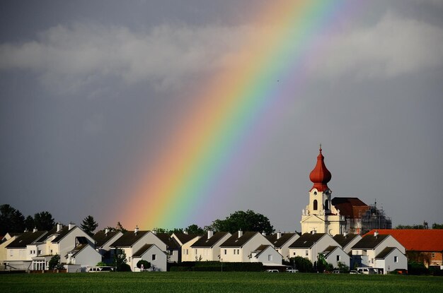 Arcobaleno in villaggio con chiesa