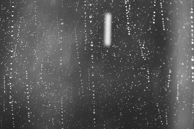 Raindrops flow down the glass