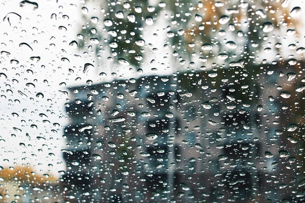 秋の街の背景にガラスの雨滴