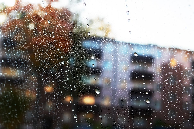 Raindrops on glass on background of autumn city