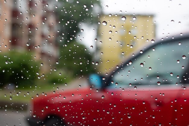 Raindrops on glass on background of car