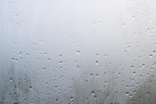 Raindrops on glass closeup background or texture