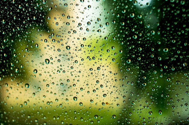 緑の背景のガラスの雨滴