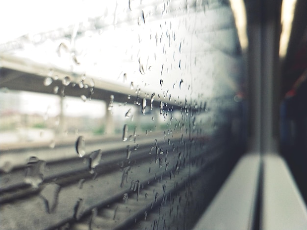 Photo raindrops on glass window of train