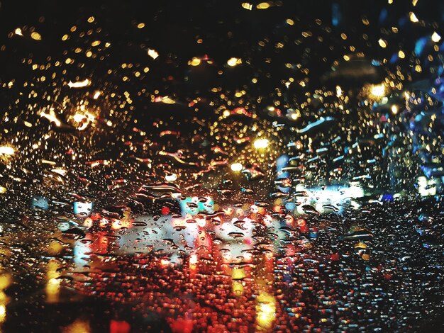 Photo raindrops on illuminated road in city at night