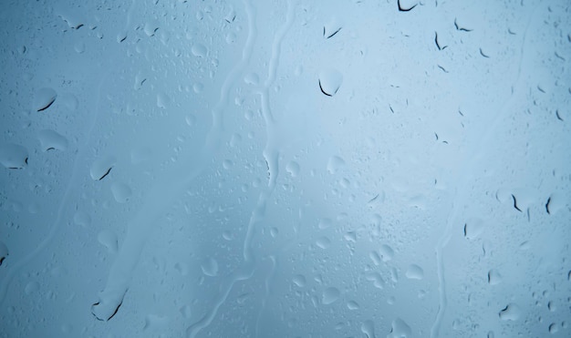 Фото Капли дождя на окне. синий тон