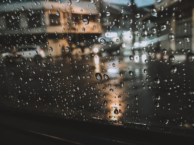 Foto le gocce di pioggia che si aggrappano al vetro di notte danno una sensazione di solitudine.