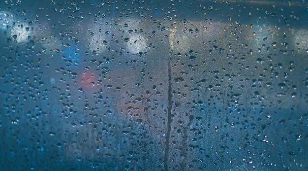 Photo raindrops on the window of the car abstract blur bokeh of traffic and car light