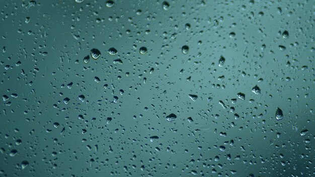 Raindrops on the window water drops descend on the window in rainy weather rack focus