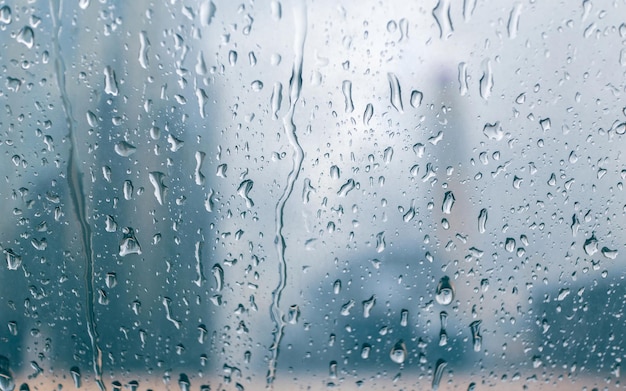 Raindrops over the window with buildings of the city in the background