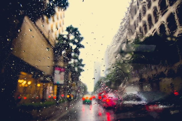 Raining drops on the car window in the traffic jam city