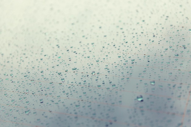 rainy weather and vehicles concept - close up of wet rear car glass