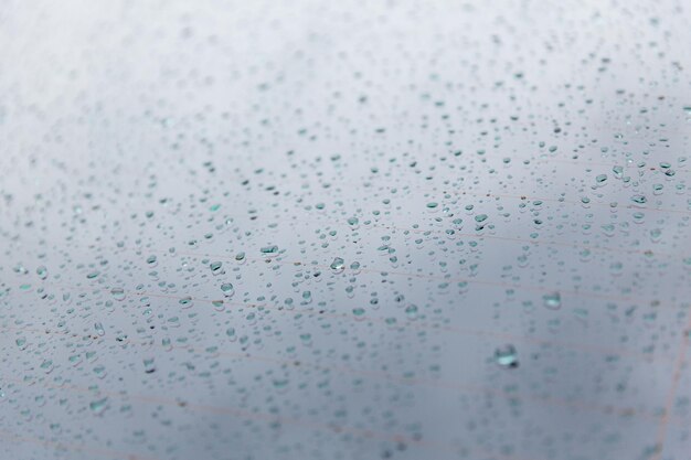 rainy weather and vehicles concept - close up of wet rear car glass