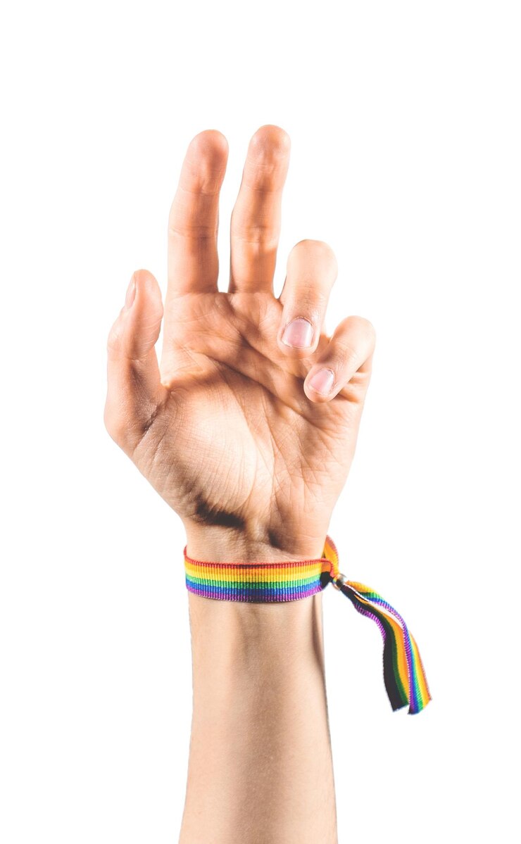 LGBTの旗の色のブレスレットを身に着けている上げられた腕