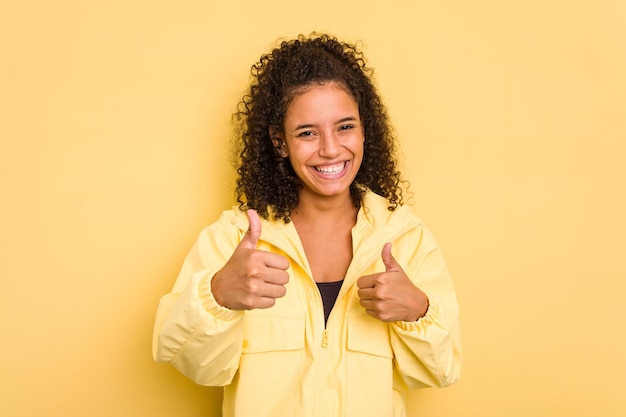 Raising both thumbs up smiling and confident